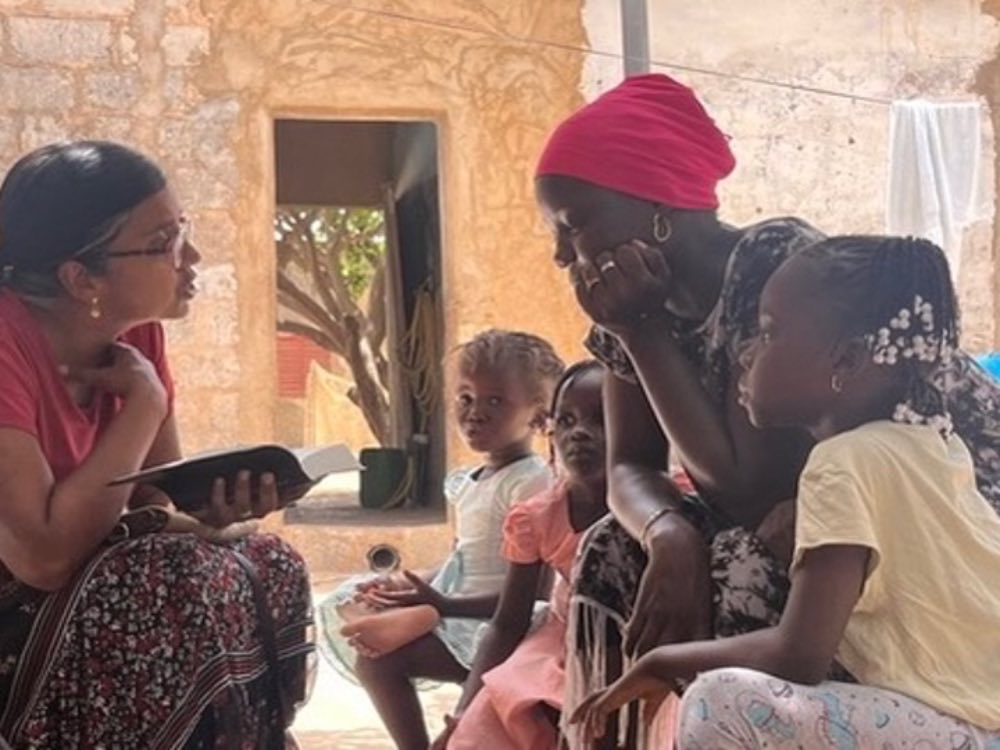 Suja Brane reading the Bible with a mother and her children