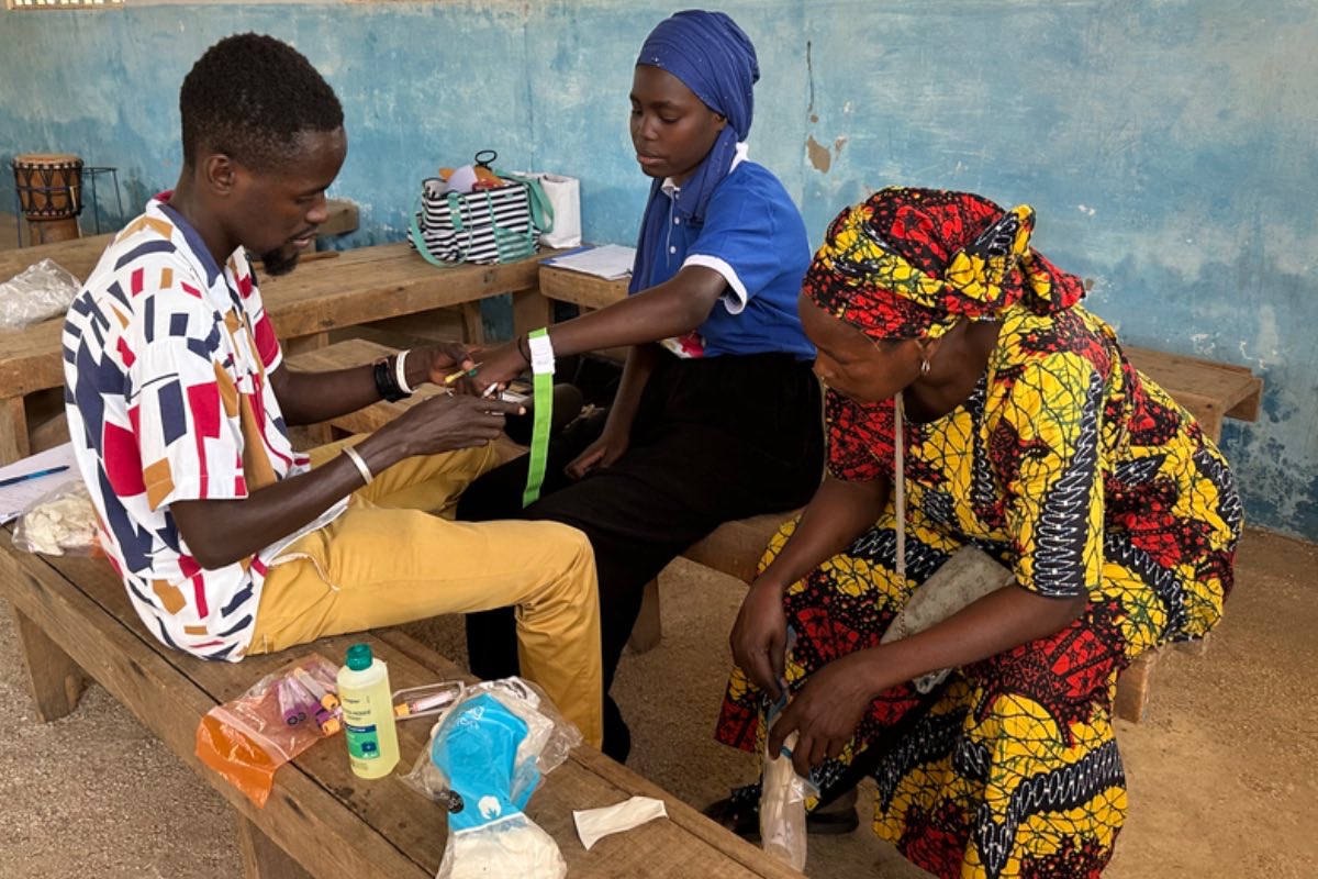 A health worker measuring a child's arm during a screening