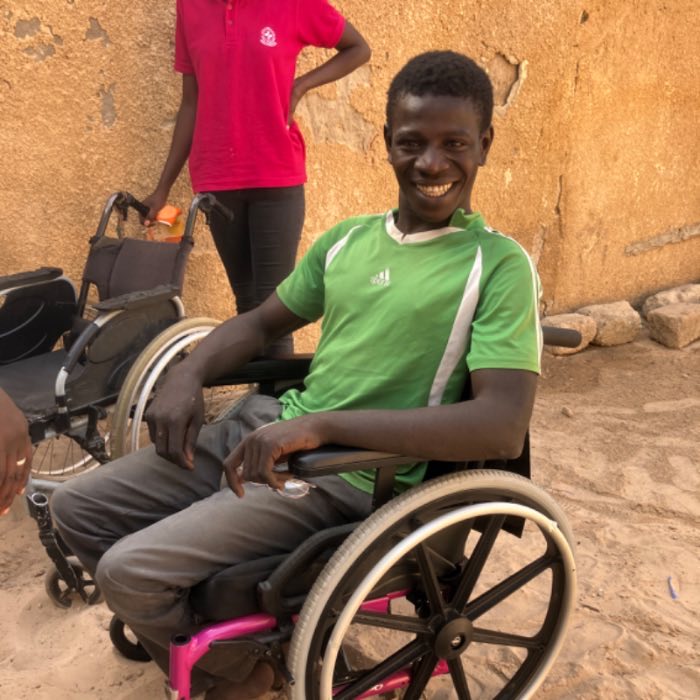 A young man smiling in his wheelchair